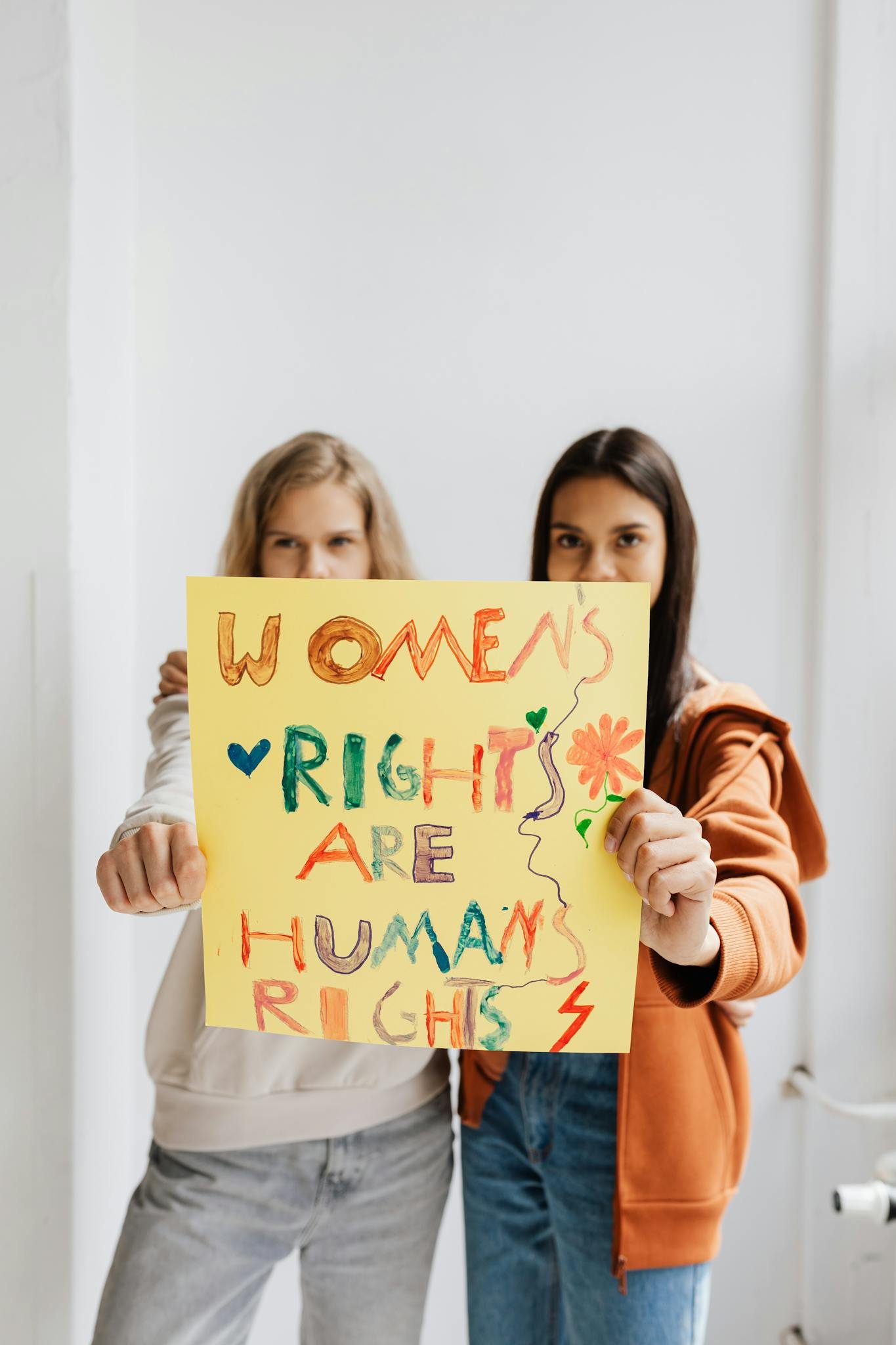 Two Women Holding A Sign Advocating Womens